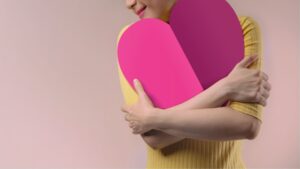 ハート型のボードを抱える女性