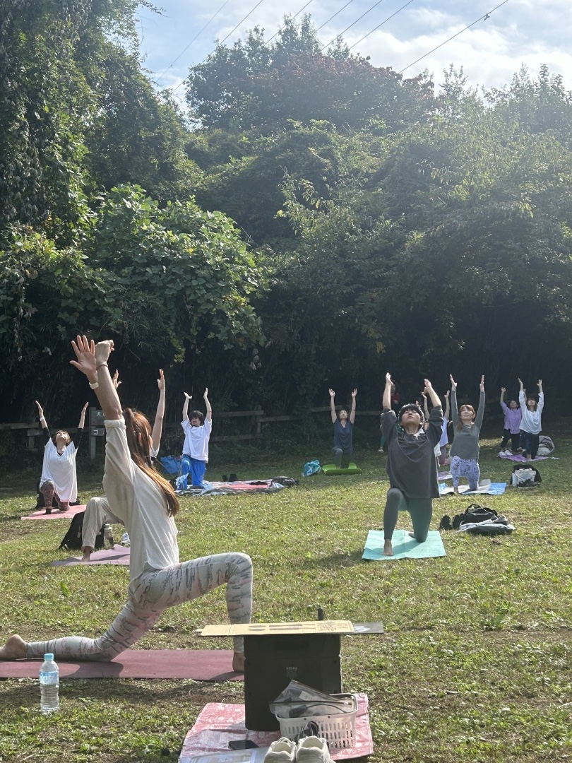 公園でヨガイベントをする修了生。三日月のポーズで生徒さんの前に登壇している