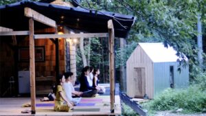 受講生たちがテラスでマットの上にアグラで目を閉じている