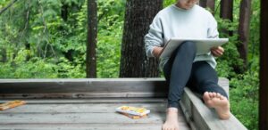 女性が画用紙に絵を描く。テラスにて
